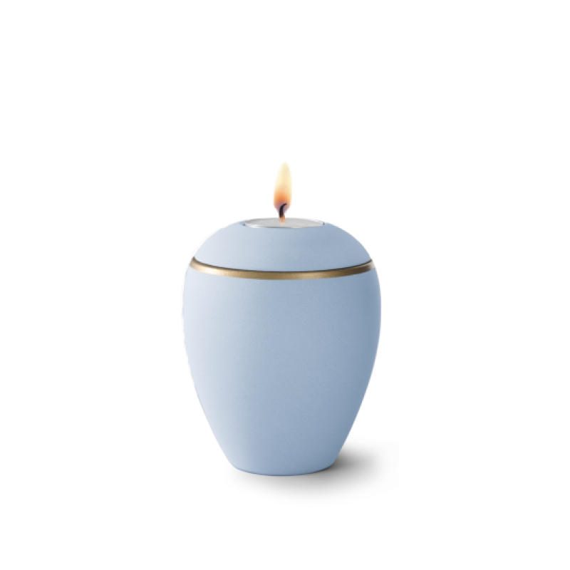 Gedenklicht aus Keramik in samtigem himmelblau mit einem altgoldenen Dekorstreifen, in ovaler Form und mit brennender Flamme, Gesamtansicht.