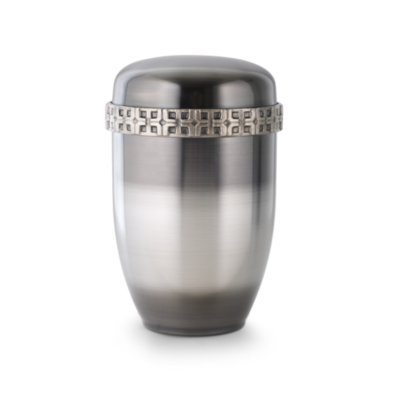 Die Urne Cestal ist galvanisch gefärbt, hat eine ovale Form in Grau und Silber mit einem dekorativen Kreuz-Gussdekor am Rand des Deckels.