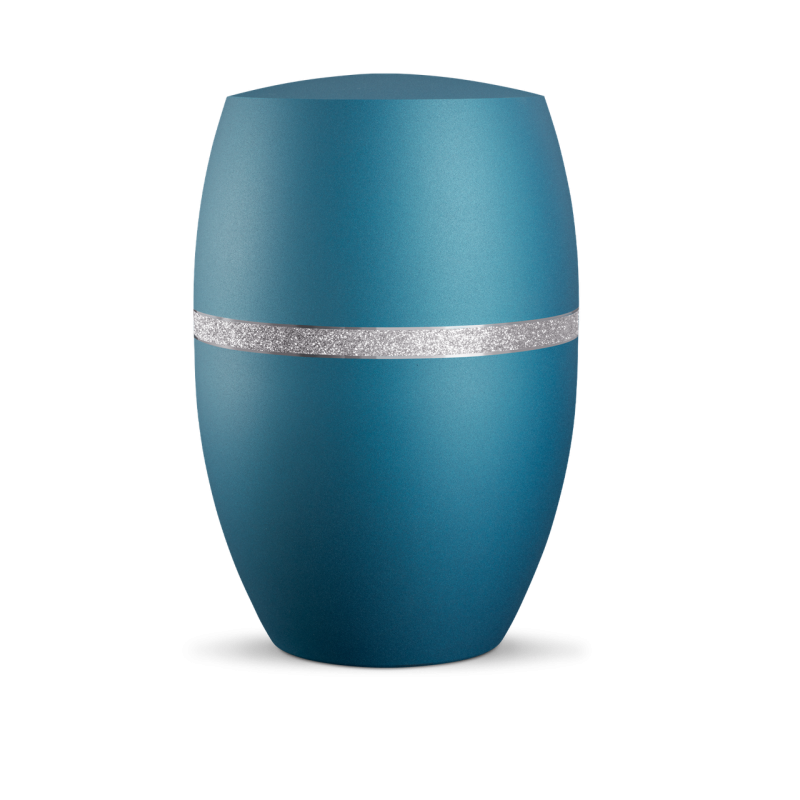 Die Urne in velvet Arctic Türkis hat eine ovale Form, eine matte Oberfläche und ist mit einem silber glitzernden Dekor in der Mitte verziert.