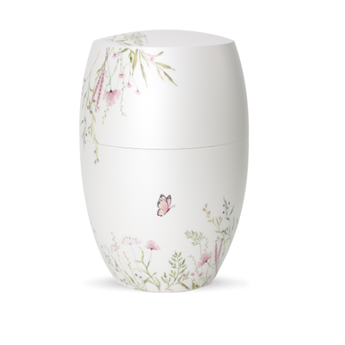 Die Urne aus der Edition Botanique ist in Perlmutt-Mattweiß gehalten und zeigt eine Blumenwiese in Rosa mit einem Schmetterling, in ovaler Form und Gesamtansicht.