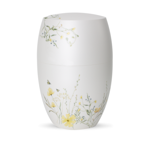 Die Urne aus der Edition Botanique ist in Perlmutt-Mattweiß gehalten und zeigt eine Blumenwiese in Gelb, mit floralen Motiven auf der Oberfläche.