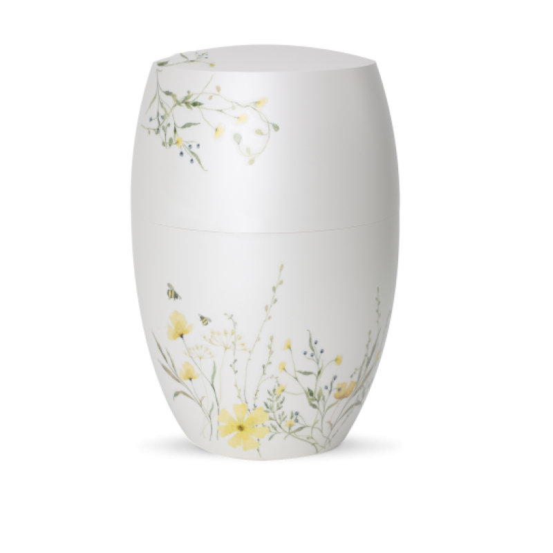 Die Urne aus der Edition Botanique ist in Perlmutt-Mattweiß gehalten und zeigt eine Blumenwiese in Gelb, mit floralen Motiven auf der Oberfläche.