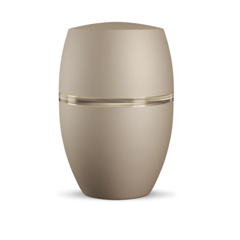 Die Urne Infinity Sorrento in velvet Champagner hat eine ovale Form mit Wellendekor und einer goldenen Linie, die den oberen und unteren Teil trennt.