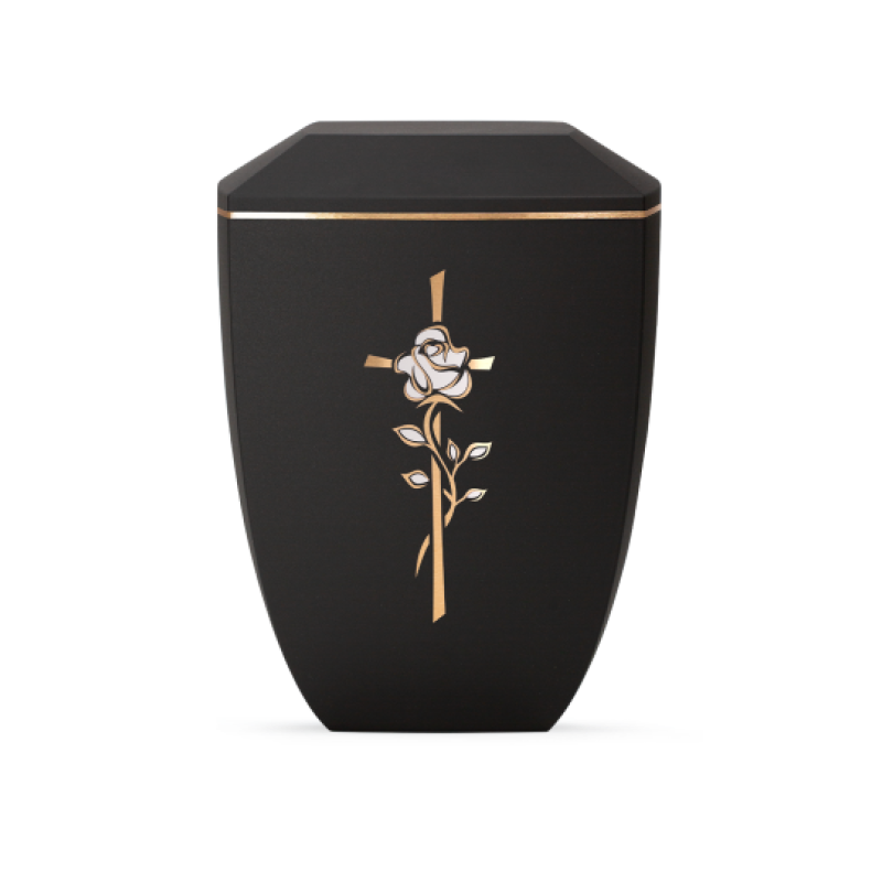 Die Urne aus der Edition Facette in Velvet Schwarz hat eine sechseckige Form, ist mit einem goldenen Kreuz und einer Rose verziert und besteht aus biologisch abbaubarem Material.