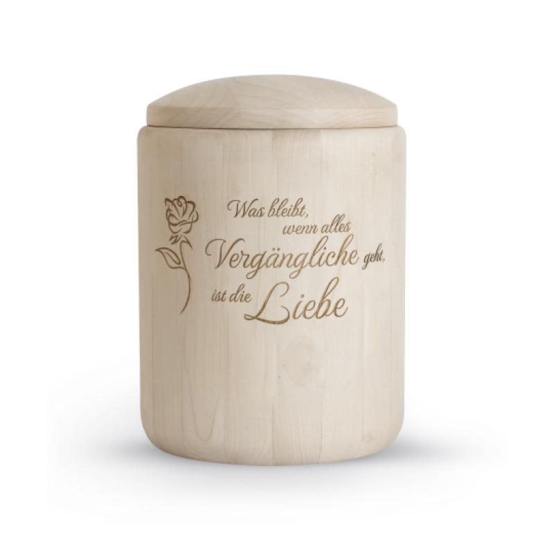 Die Urne aus unbehandeltem Holz hat eine zylindrische Form, einen abgerundeten Deckel und ist mit einer Lasergravur versehen, die einen Text und eine Rose zeigt.