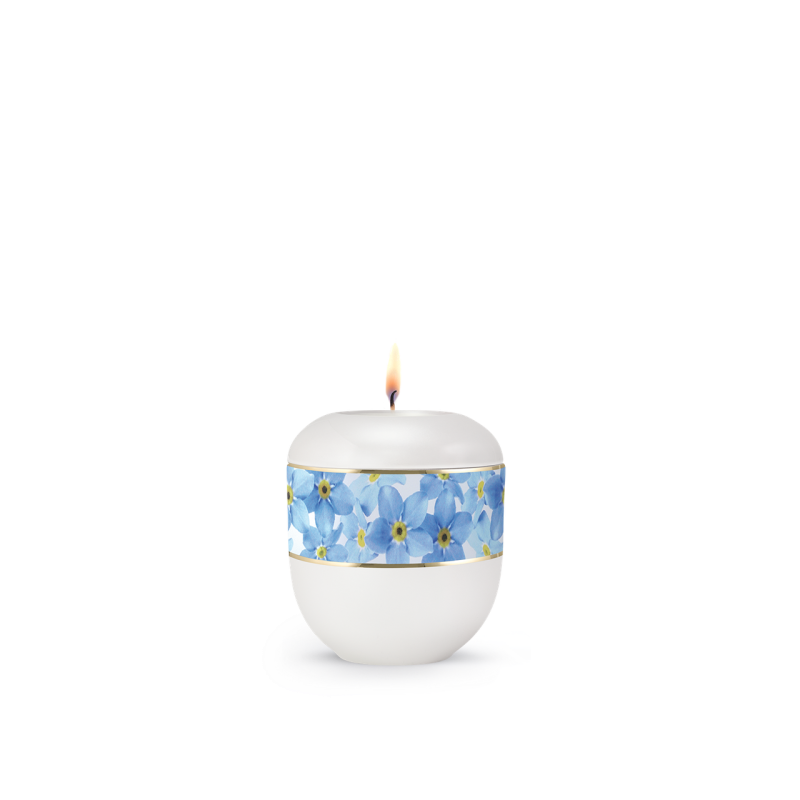 Gedenklicht in Weiß mit einem blauen Vergissmeinnicht-Motiv und goldener Umrandung, rundliche Form, Gesamtansicht mit brennender Flamme.