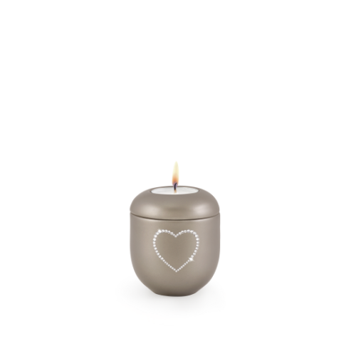 Gedenklicht aus perlmutt fumé mit herzförmigem Kristallmotiv, runde Form, mattierte Oberfläche und brennender Kerze oben, Gesamtansicht.