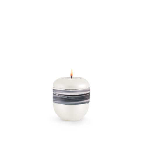 Gedenklicht aus der Edition Wave in Perlmuttfarbe mit einem silbernen Streifen und Wellenmotiv, runde Form, Gesamtansicht mit brennender Flamme.