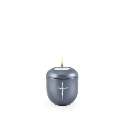 Gedenklicht in perlmutt mitternachtsblau, rundliche Form mit Kristallkreuz, brennend, Gesamtansicht.