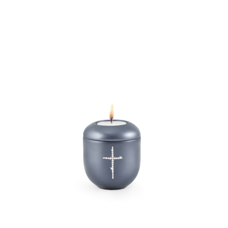 Gedenklicht in perlmutt mitternachtsblau, rundliche Form mit Kristallkreuz, brennend, Gesamtansicht.