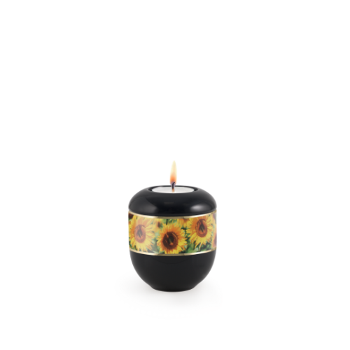 Gedenklicht in schwarz mit einem bunten Sonnenblumenmotiv, runde Form, brennende Flamme oben, Gesamtansicht.