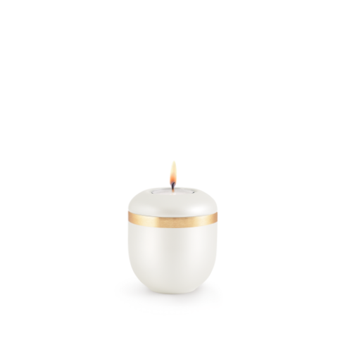 Ein Gedenklicht in Perlmuttfarbe mit einem gebürsteten Goldband, rundlich geformt und mit einer brennenden Flamme, Gesamtansicht.