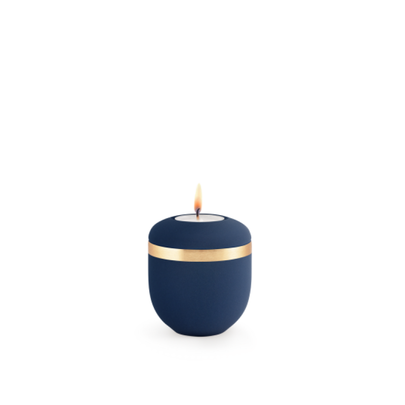 Ein rundes, mattes Gedenklicht in Marineblau mit einem gebürsteten Goldband, das eine Flamme in der Mitte zeigt.