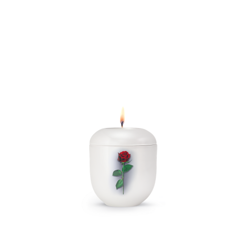 Ein weißes Gedenklicht mit einer roten Rose als Dekor, in runder Form und mit brennender Flamme, Gesamtansicht des Produkts aus der Edition Fleur von Goetz.
