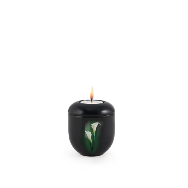 Gedenklicht in Klavierlack schwarz mit einer Calla-Motiv-Dekoration, runde Form, brennende Kerze auf der Oberseite, Gesamtansicht.