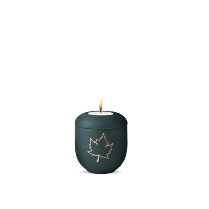 Ein Gedenklicht in der Farbe velvet petrol mit kupferfarbenem Ahornblatt-Motiv, rundlicher Form und brennender Kerze oben, Gesamtansicht.