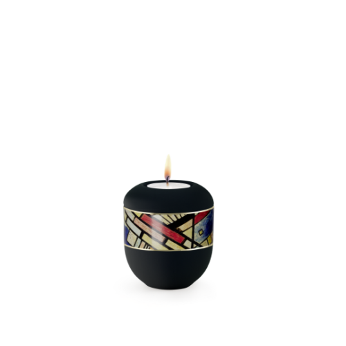 Gedenklicht aus der Edition Arte in schwarz mit umlaufendem, buntem Linienmotiv und brennender Kerze, in runder Form und mattem Finish.
