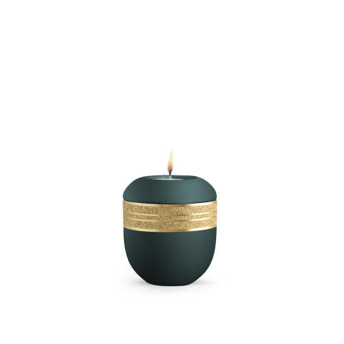 Gedenklicht in der Farbe velvet Petrol mit mattgoldenem, glitzerndem Dekor und runder Form, Gesamtansicht mit brennender Kerze.