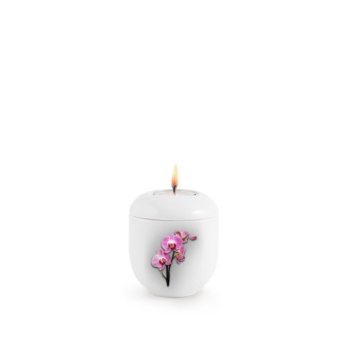 Gedenklicht in weißer Farbe mit einer stilisierten Orchideen-Dekoration in Pink, runde Form, Gesamtansicht mit brennender Flamme oben.
