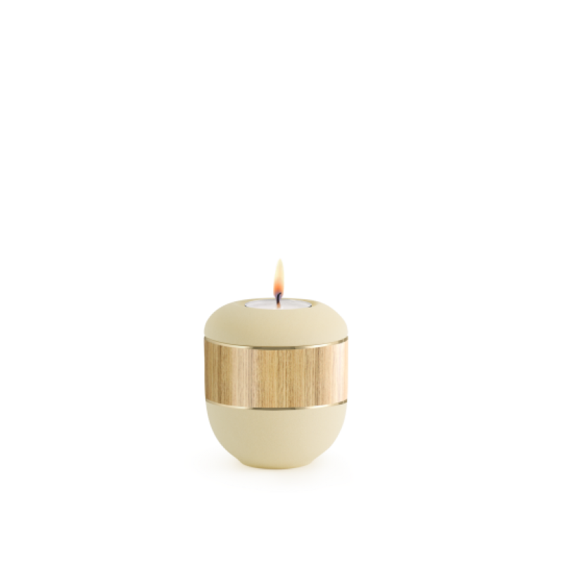 Gedenklicht in Samtton creme mit dekorativer, holzähnlicher Bandapplikation, rundliche Form und brennender Flamme, Gesamtansicht.