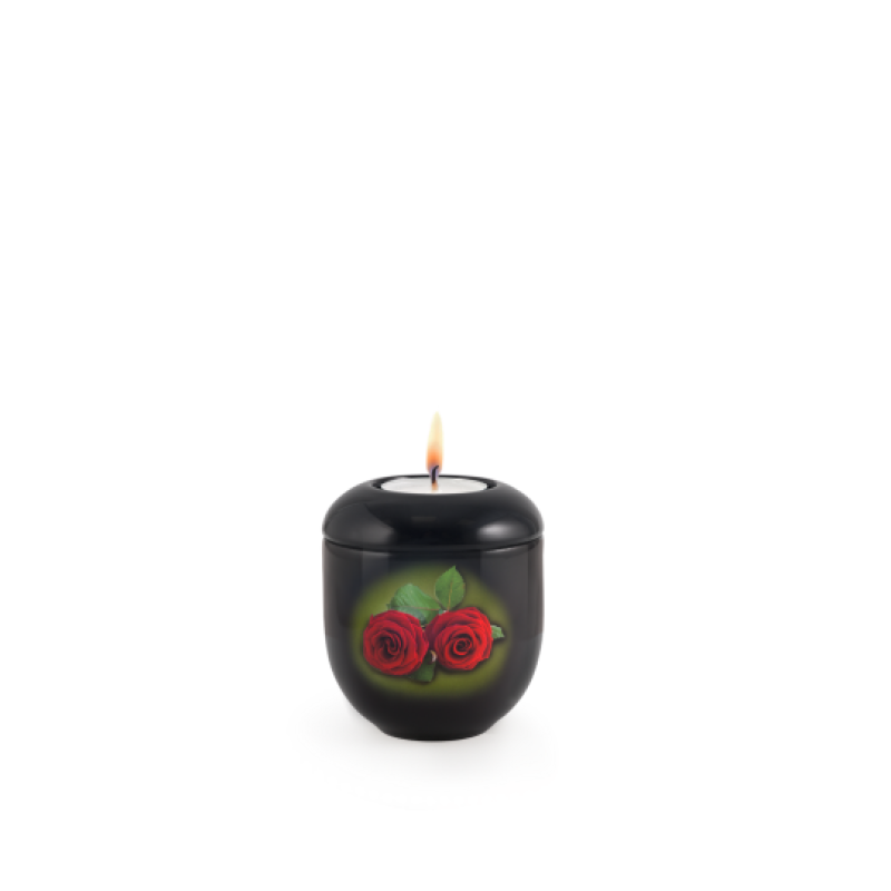 Gedenklicht in schwarz mit einer Abbildung von roten Rosen, runde Form, aus Metall, Gesamtansicht mit brennender Kerze oben.