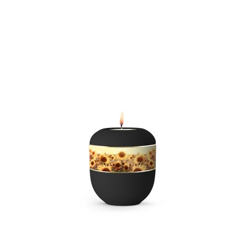 Die schwarze Urne aus Porzellan der Edition Ventura hat eine runde Form, ein umlaufendes Zierband mit Sonnenblumenmotiven und eine Kerzenöffnung oben.