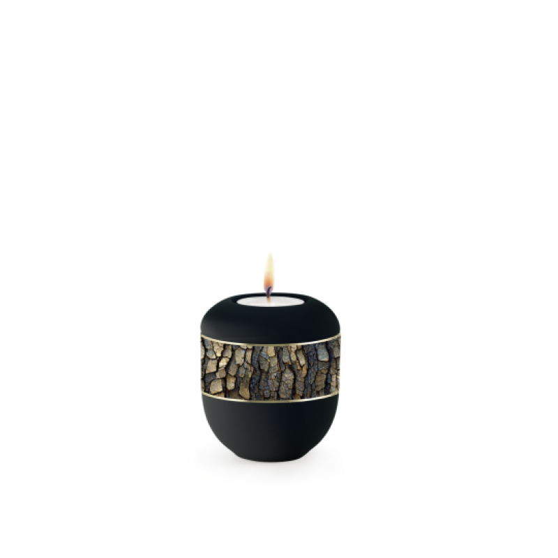 Die Urne aus der Edition Ventura ist schwarz, hat eine runde Form, ein umlaufendes Zierband aus Erle und einen Porzellan-Brenner mit einer Flamme.