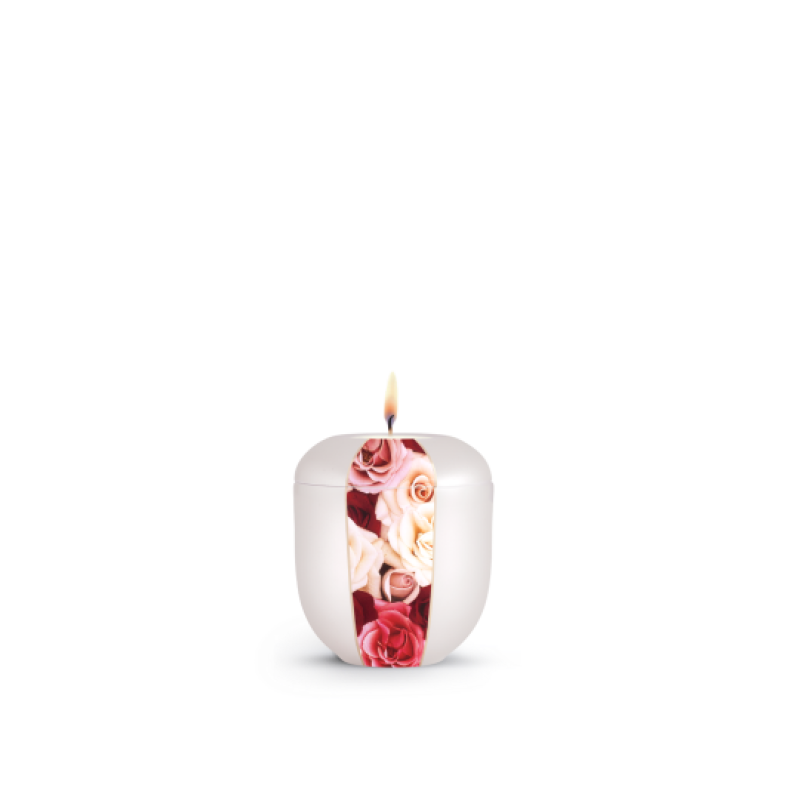 Ein Gedenklicht aus Perlmutt mit einer floralen Dekoration in Rosa- und Rottönen, in runder Form und mit brennender Flamme, Gesamtansicht.