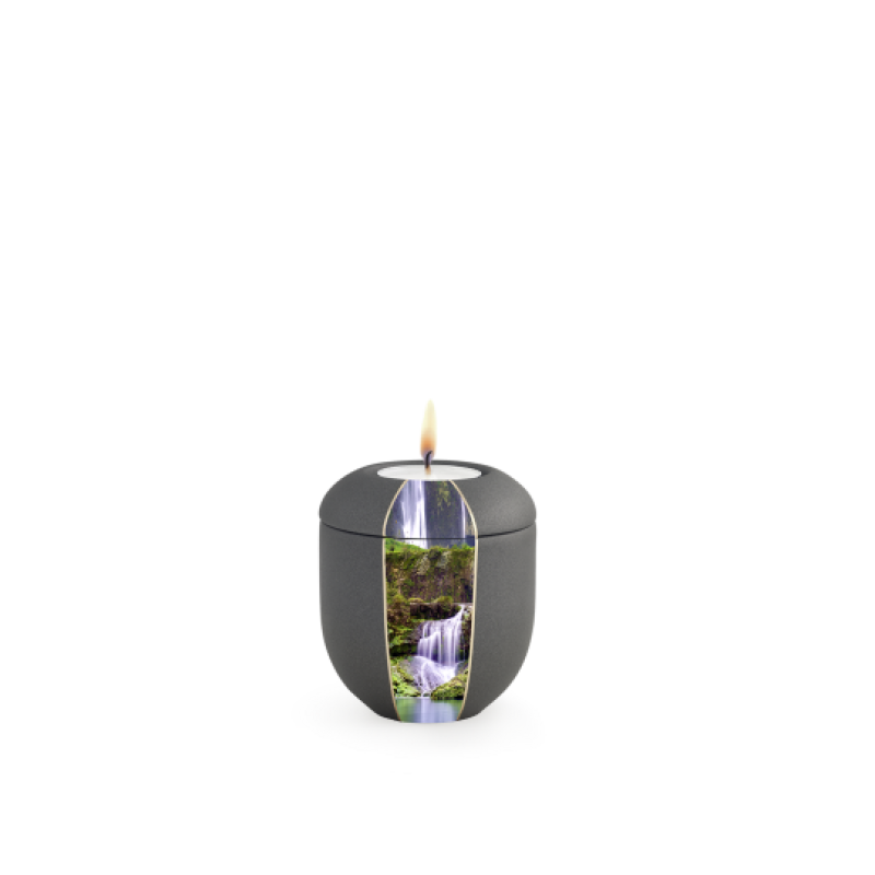 Ein anthrazitfarbenes Gedenklicht mit Wasserfallmotiv, rundlich geformt, aus mattem Material, mit einer flammenbeheizten Öffnung oben.