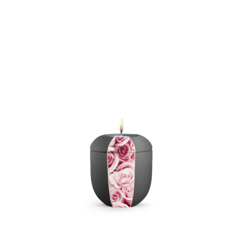 Die Gedenklicht-Urne in Samtton anthrazit hat eine ovale Form und ist mit einer dekorativen Fläche aus rosa Rosen verziert, die einen sanften Kontrast bildet.