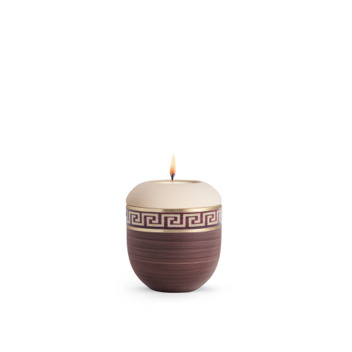 Ein handbemaltes Gedenklicht in Kastanienbraun und Creme mit einem Mäander-Muster, ovaler Form und einer flammenbeheizten Öffnung oben.