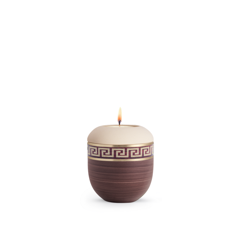 Ein handbemaltes Gedenklicht in Kastanienbraun und Creme mit einem Mäander-Muster, ovaler Form und einer flammenbeheizten Öffnung oben.