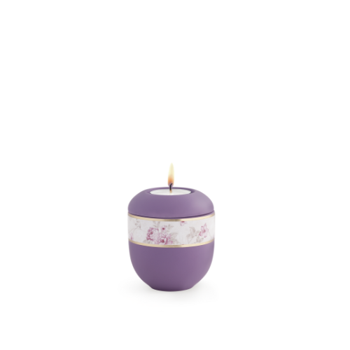 Ein lila Gedenklicht aus der Edition Pastell mit Soft-Touch-Oberfläche und Blumendekor, in runder Form mit einer goldenen Verzierungsband.