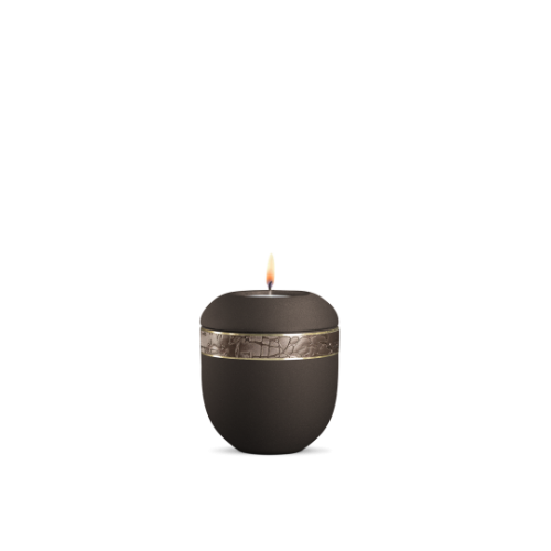 Ein braunes Gedenklicht mit einer runden Form, strukturiertem Dekor und einem goldenen Band, das eine Flamme trägt, in Gesamtansicht.