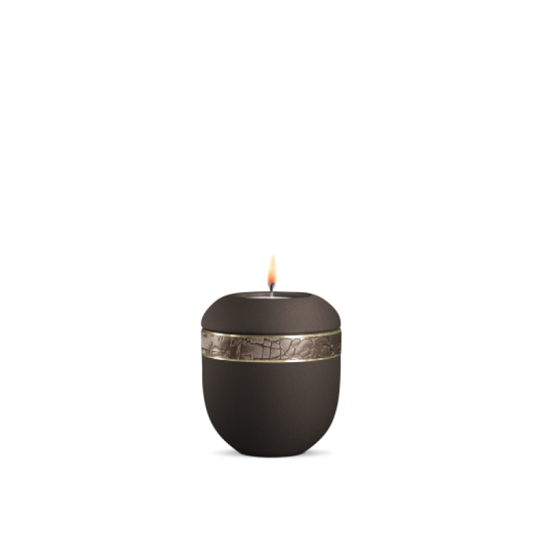 Ein braunes Gedenklicht mit einer runden Form, strukturiertem Dekor und einem goldenen Band, das eine Flamme trägt, in Gesamtansicht.