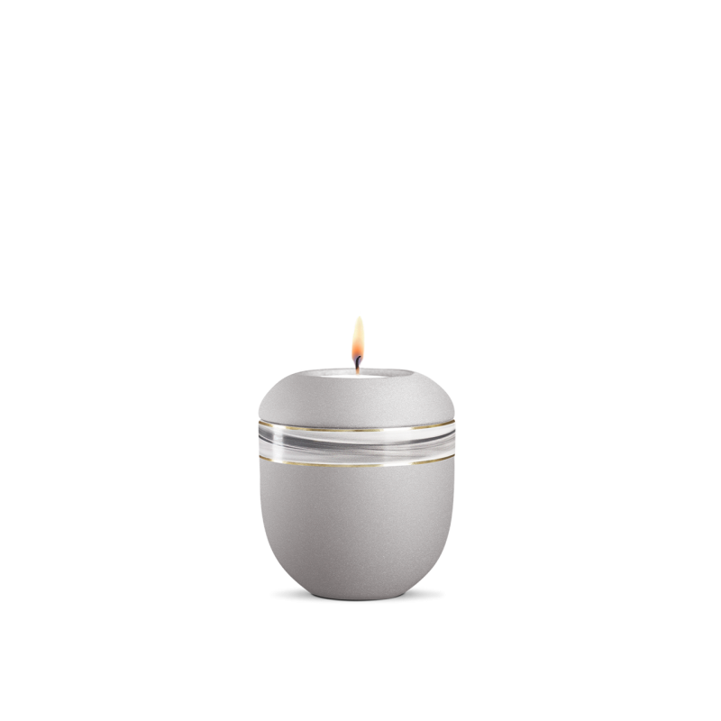 Ein silbergraues Gedenklicht mit Wellendekor, aus mattem Material, in runder Form, mit einer flammenden Kerze auf der Oberseite, Gesamtansicht.