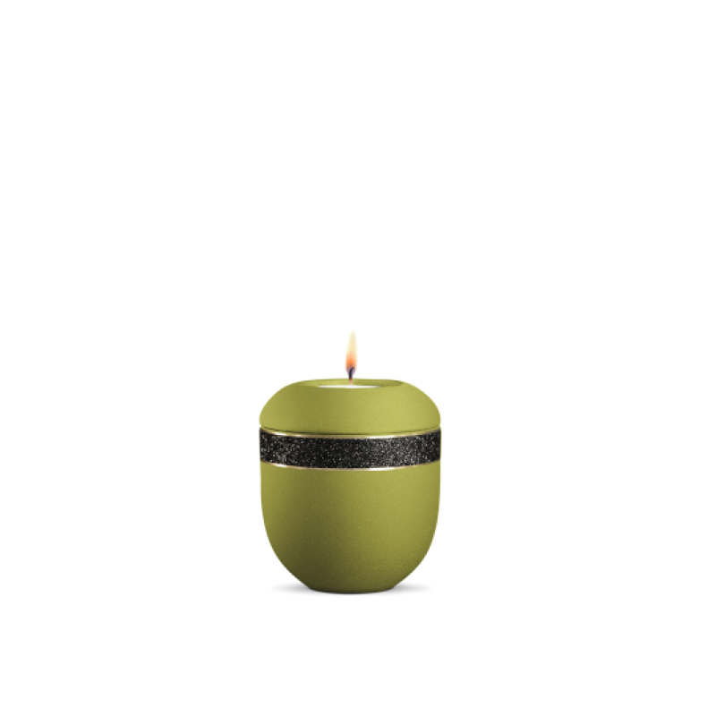 Gedenklicht in ovaler Form, aus mattem Peridot-Grün mit schwarzem glitzerndem Dekor, brennend, Gesamtansicht.