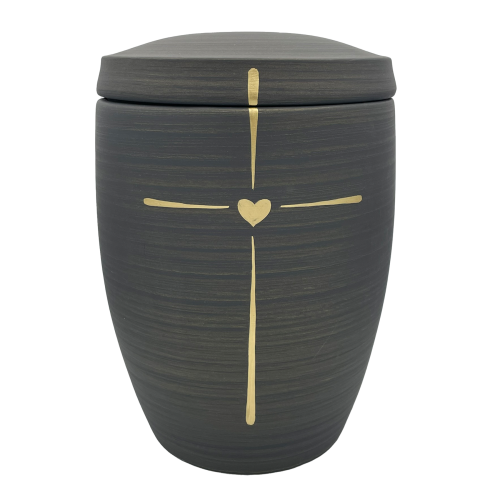 Eine graue Urne mit einer glänzenden goldenen Kreuz- und Herzdekoration, in runder Form und mit einem abnehmbaren Deckel.