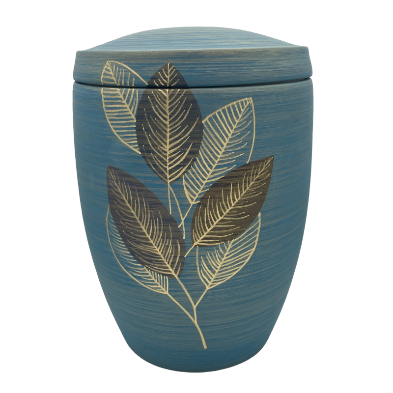 Die edle Urne in Blau hat eine runde Form und ist mit goldenen Blättern verziert, die einen eleganten Kontrast zur matten Oberfläche bilden.