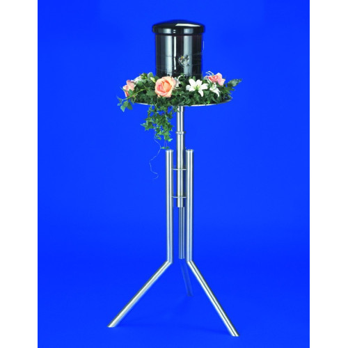 Ein Urnenkandelaber aus Edelstahl mit drei stabilen Füßen, einer runden Ablagefläche, einer schwarzen Urne und floraler Dekoration in Rosa und Weiß.