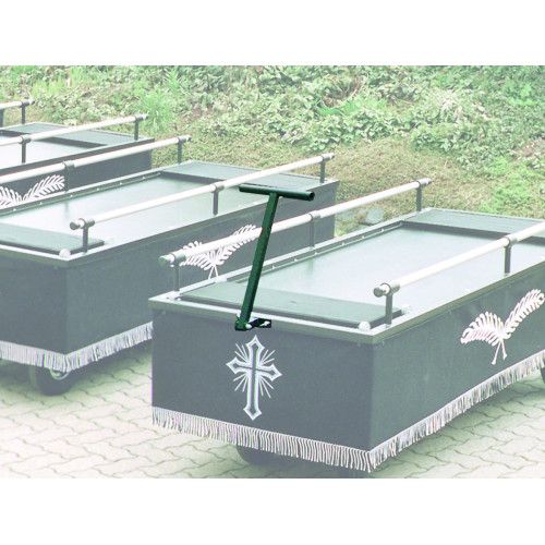 Abklappbare Zugdeichsel in Grün für Sargwagen, sichtbar an einem Sargwagen mit schwarzer Oberfläche und Fransen, im Hintergrund weitere Sargwagen.