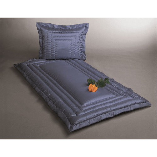 Die Glanzseide in Blau ist als Kissen und Unterlage in rechteckiger Form gestaltet, mit einer glatten Oberfläche und einer dezenten Raffung, dekoriert mit einer Rose.