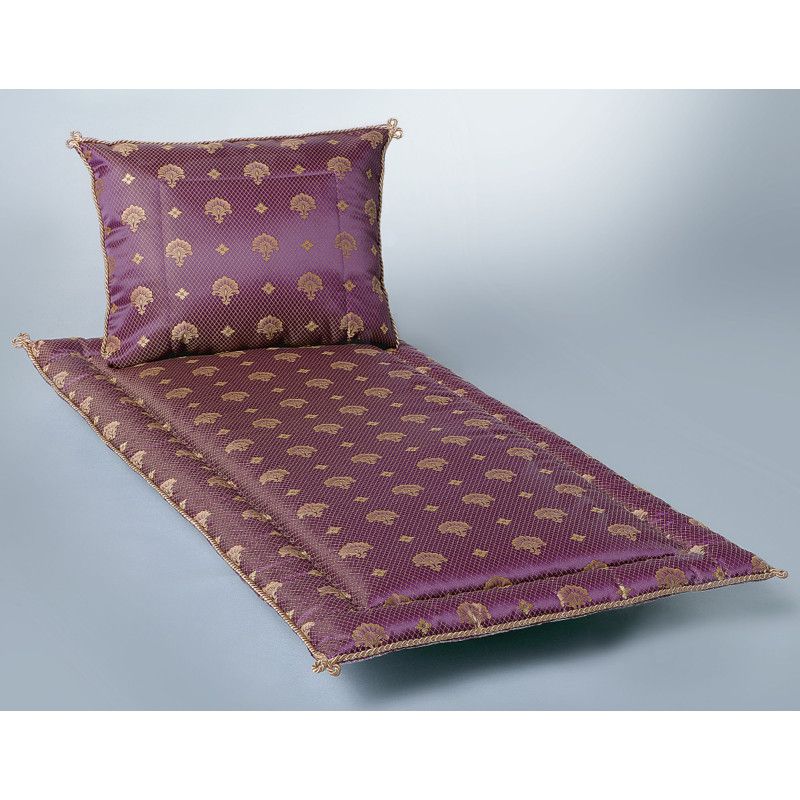 Ein bordeauxfarbenes Jacquard Pesante mit goldenen Mustern, bestehend aus einer Liegefläche und einem Kopfkissen, in Gesamtansicht.