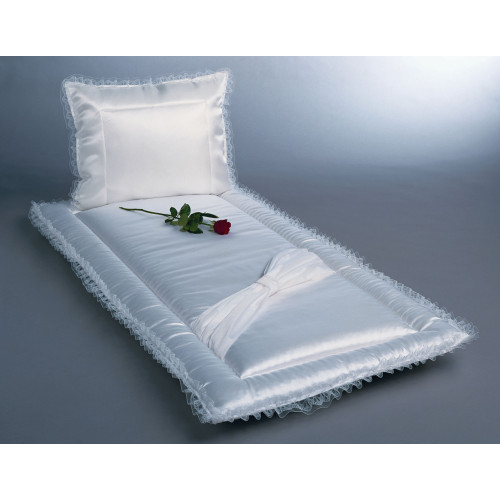 Ein weißes Serge mit Schleife, bestehend aus einem Kissen und einer Unterlage, mit Rüschenrand und einer roten Rose auf der Fläche, Gesamtansicht.