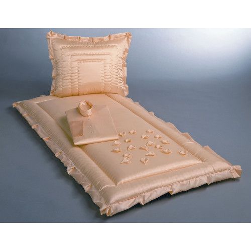 Glanzseide in Vanillefarbe mit Blüten, bestehend aus einem Kissen, einer Decke und einem Deckchen, alles mit Rüschen und in einer Gesamtansicht präsentiert.