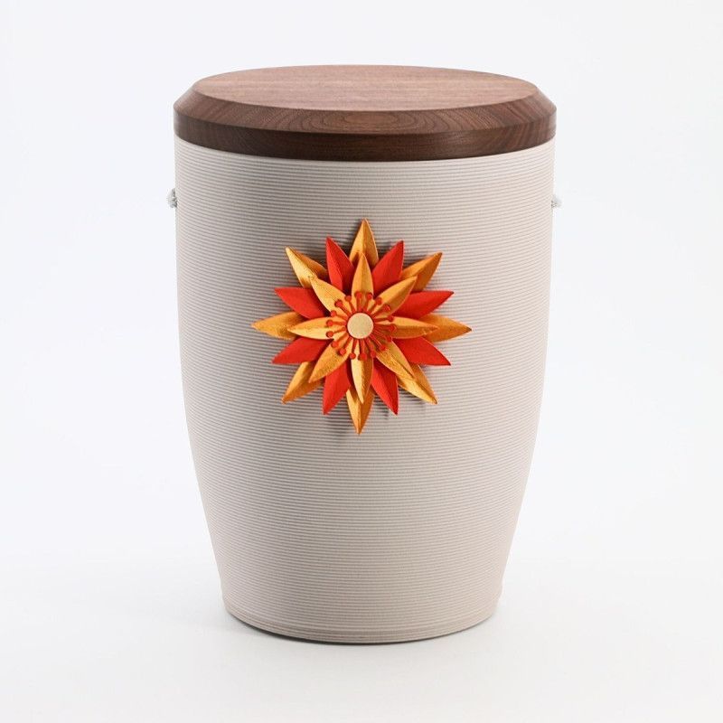 Die Urne Stille Blüte in Rot Grau aus Tonerde hat eine ovale Form, eine strukturierte Oberfläche und ist mit einer blütenförmigen, rot-gelben Dekoration verziert.