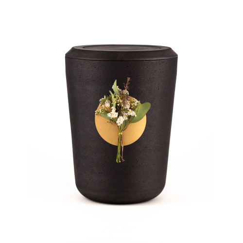 Die Kohleurne Eukalyptus ist schwarz, zylindrisch geformt und hat eine runde, goldfarbene Fläche mit einer Blumenarrangement-Dekoration.