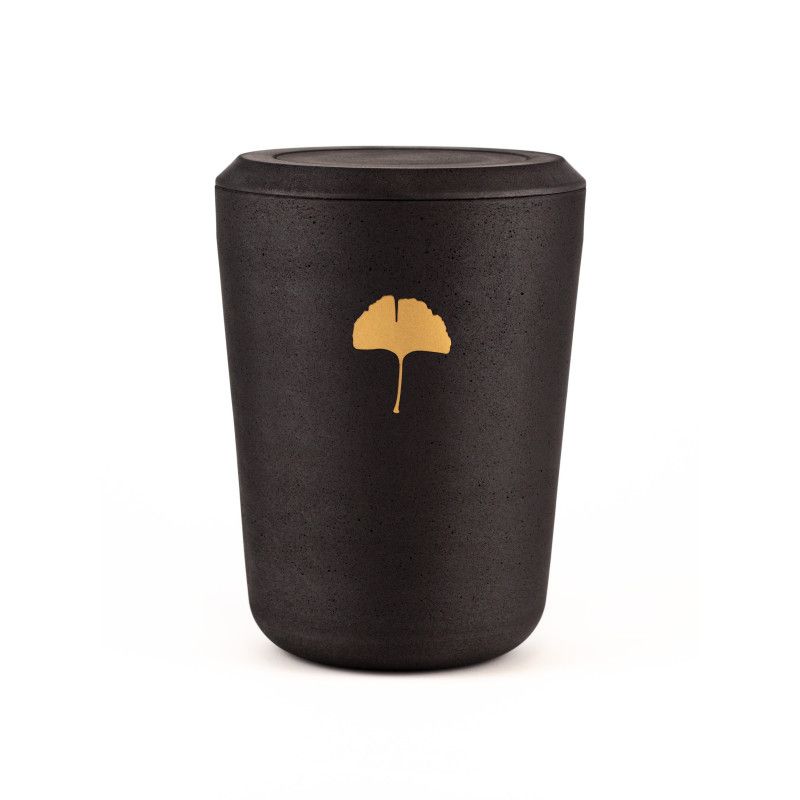 Die Kohleurne in Schwarz hat eine runde Form und ist mit einem goldenen Ginkgoblatt-Symbol verziert, sichtbar in einer Gesamtansicht.