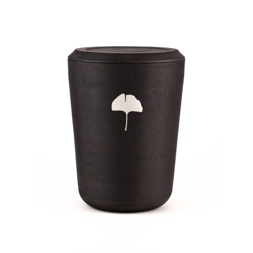 Die Kohleurne Ginkgoblatt Silber ist zylindrisch, aus mattem, schwarzem Material gefertigt und zeigt ein silbernes Ginkgoblatt als dekoratives Element.