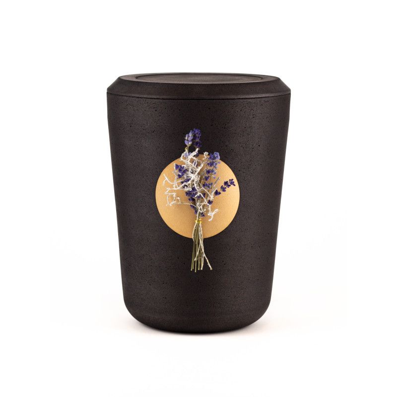 Die Kohleurne ist schwarz, zylindrisch geformt und zeigt auf der Vorderseite eine goldene Fläche mit Lavendel und Zweigen als Dekoration.